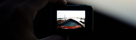 GoPro Kamera wird in der Hand gehalten und filmt ein altes kleines Holzboot