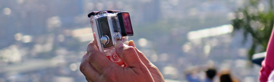 Eine Person hält eine GoPro Kamera in der Hand und filmt sich selbst - GoPro mieten