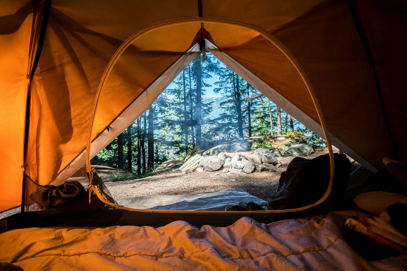 Ein Foto das aus einem Zelt ins Freie geschossen wurde: Campingausrüstung mieten