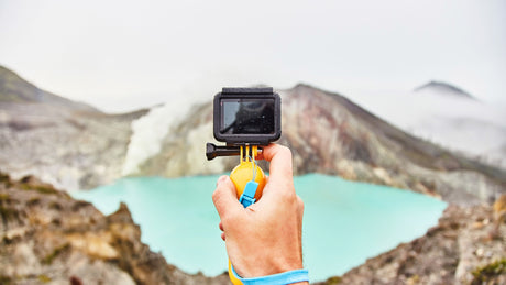 Person hält eine GoPro in der Hand und filmt einen Bergsee: Elektronik mieten