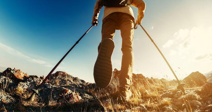 Person beim Wandern mit Stöcken: Wanderstöcke richtig einstellen