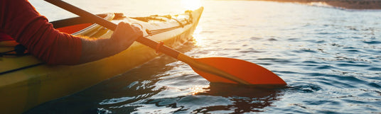 Nahaufnahme einer Person im Kajak bei Sonnenuntergang - Wassersportgeräte mieten